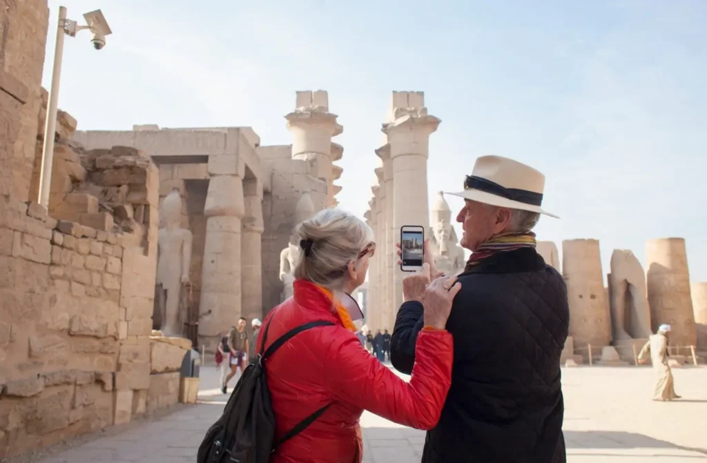 Ein älteres Paar steht zusammen vor dem Pylon des Luxor-Tempels