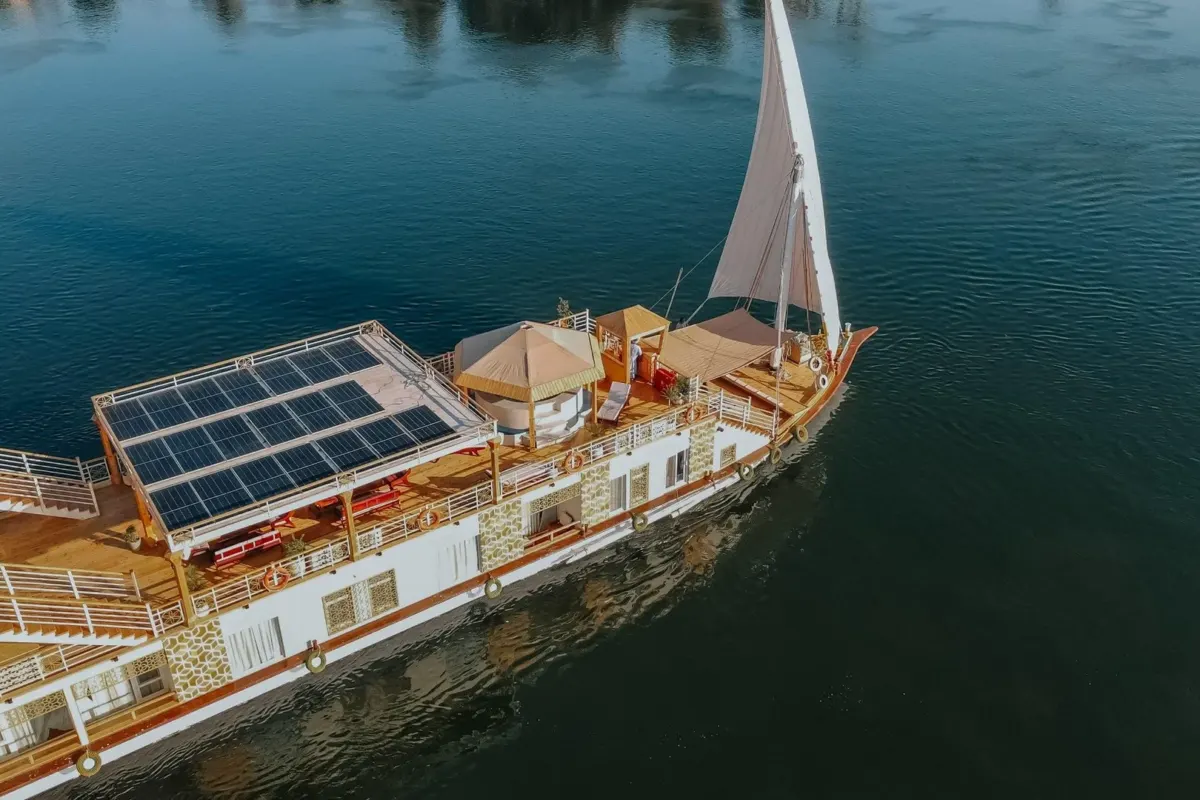 Luftaufnahme der Dahabiya Azhar unter Segeln, mit den Solarpaneelen und den schattigen Sitzplätzen auf dem Oberdeck