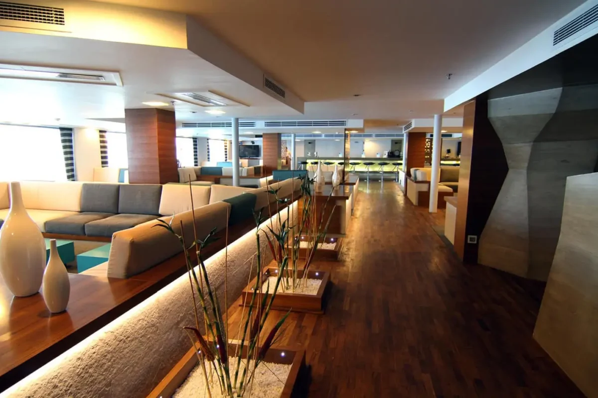 The lounge on the MS Le Fayan Nile cruise, a long banquette and low tables running down a dark timber floor