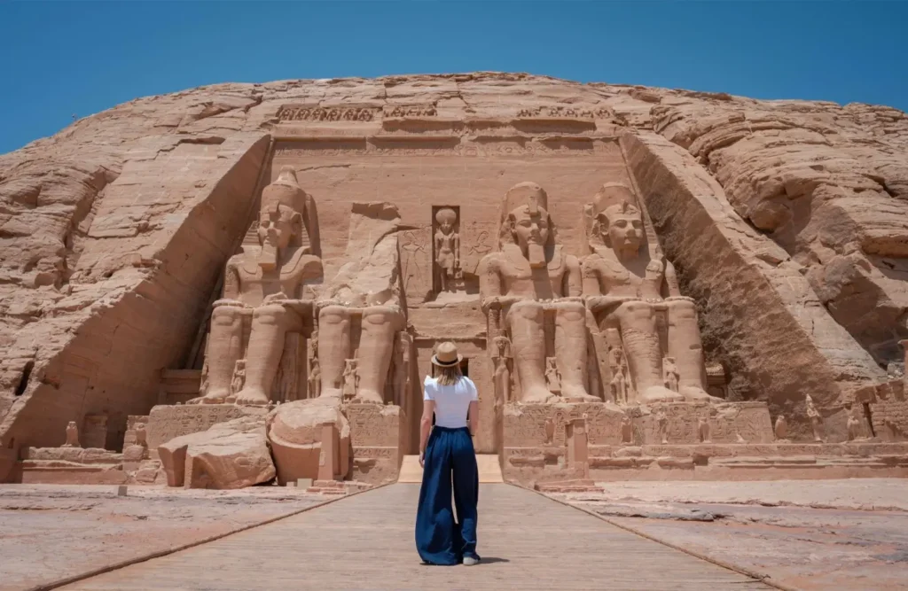 The four seated colossi of Ramses II on the facade of the Great Temple at Abu Simbel, a visitor on the walkway for scale