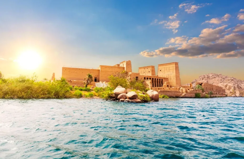 The Temple of Philae on Agilkia Island at sunset, the water of Lake Nasser bright in the foreground