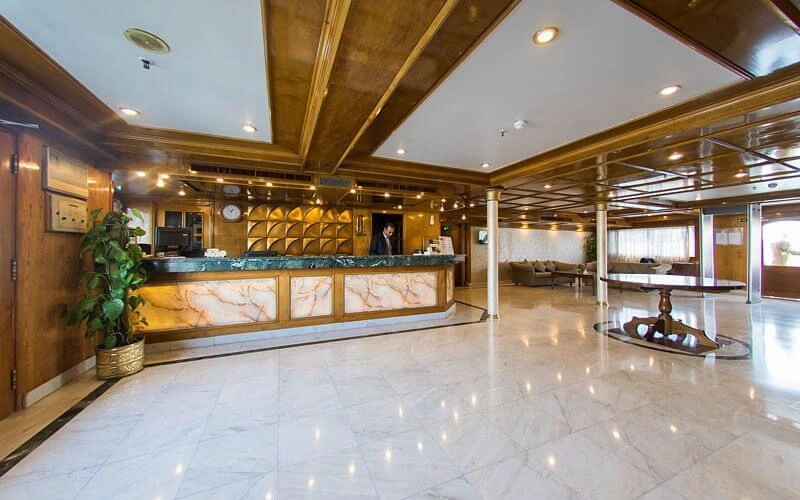 The marble reception lobby on the A Sara Nile cruise, a stone-fronted desk under wood-panelled ceilings