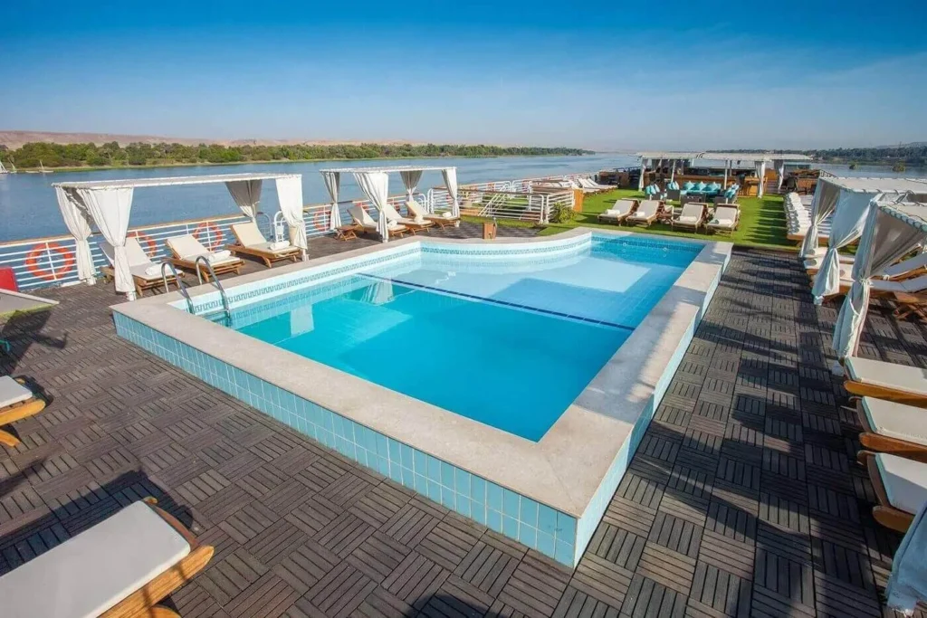 The swimming pool on the MS Acamar Nile cruise sun deck, loungers set out along the rail above the Nile