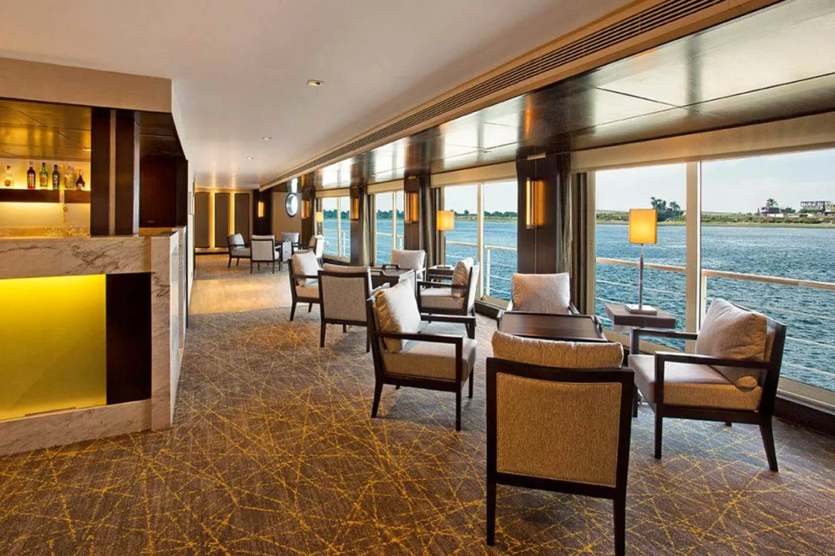 The lounge on the MS Amwaj Living Stone Nile cruise, armchairs along a long run of windows with the bar counter at the near end