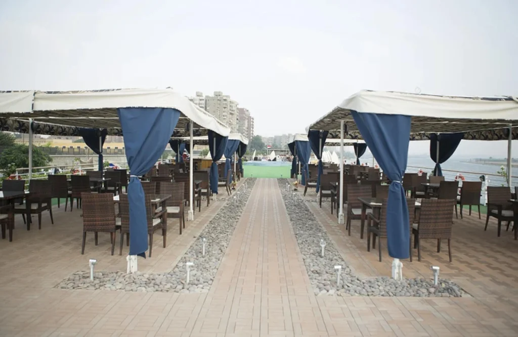 Dining tables under blue-curtained canopies on the deck of the Blue Shadow Nile cruise, a walkway running between them