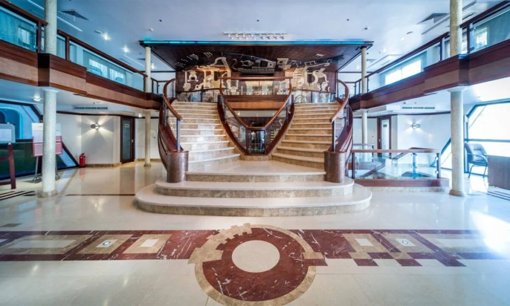 The curved staircase in the Concerto Nile cruise lobby, rising from an inlaid marble floor