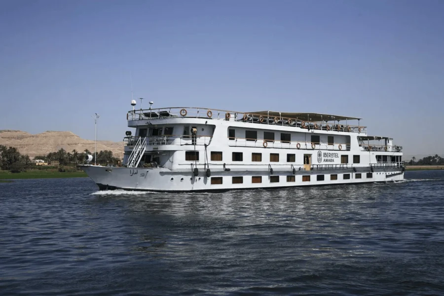 The Iberotel Amara Nile cruise ship under way on the Nile, desert hills low on the far bank