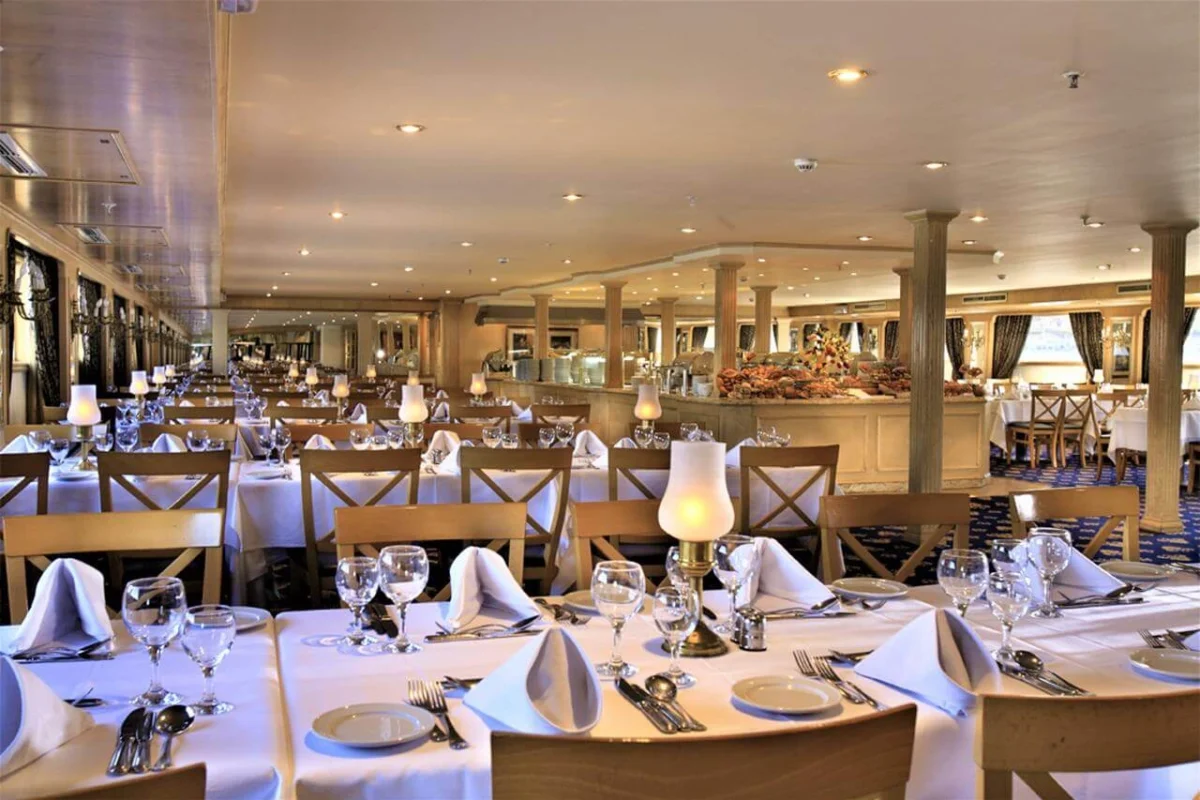 The restaurant on the Iberotel Crown Emperor Nile cruise, long rows of tables laid with glassware and folded napkins