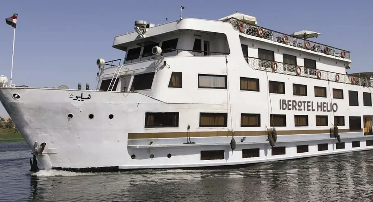 The Iberotel Helio Nile cruise ship under way on calm water, seen from the bow quarter