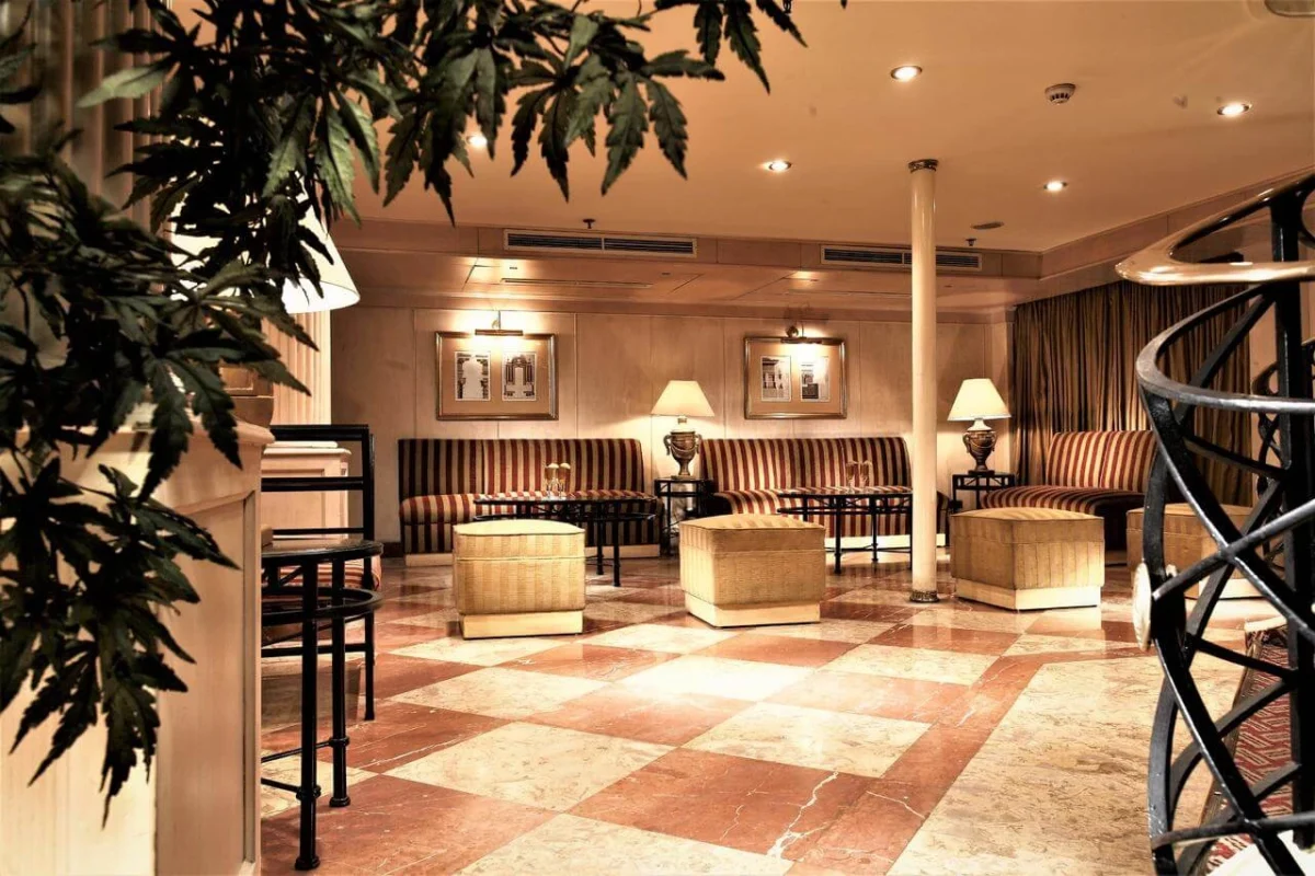 The lobby of the Jaz Crown Jewel Nile cruise, a chequered stone floor with banquette seating and a spiral staircase