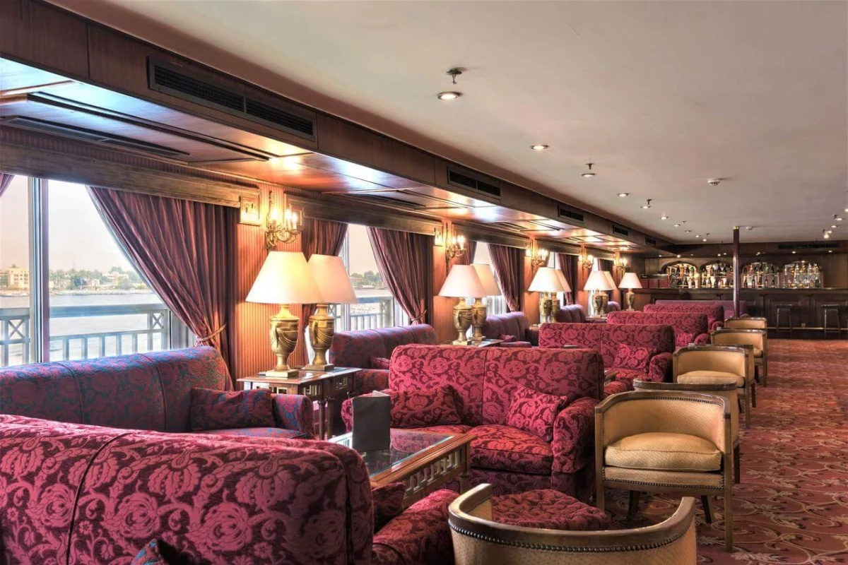 The lounge on the Jaz Crown Jewel Nile cruise, damask sofas and table lamps running the length of the river windows