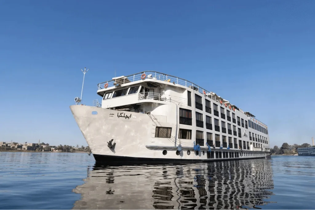 The Kleos Nile cruise ship on still water seen from the bow, its dark hull mirrored below