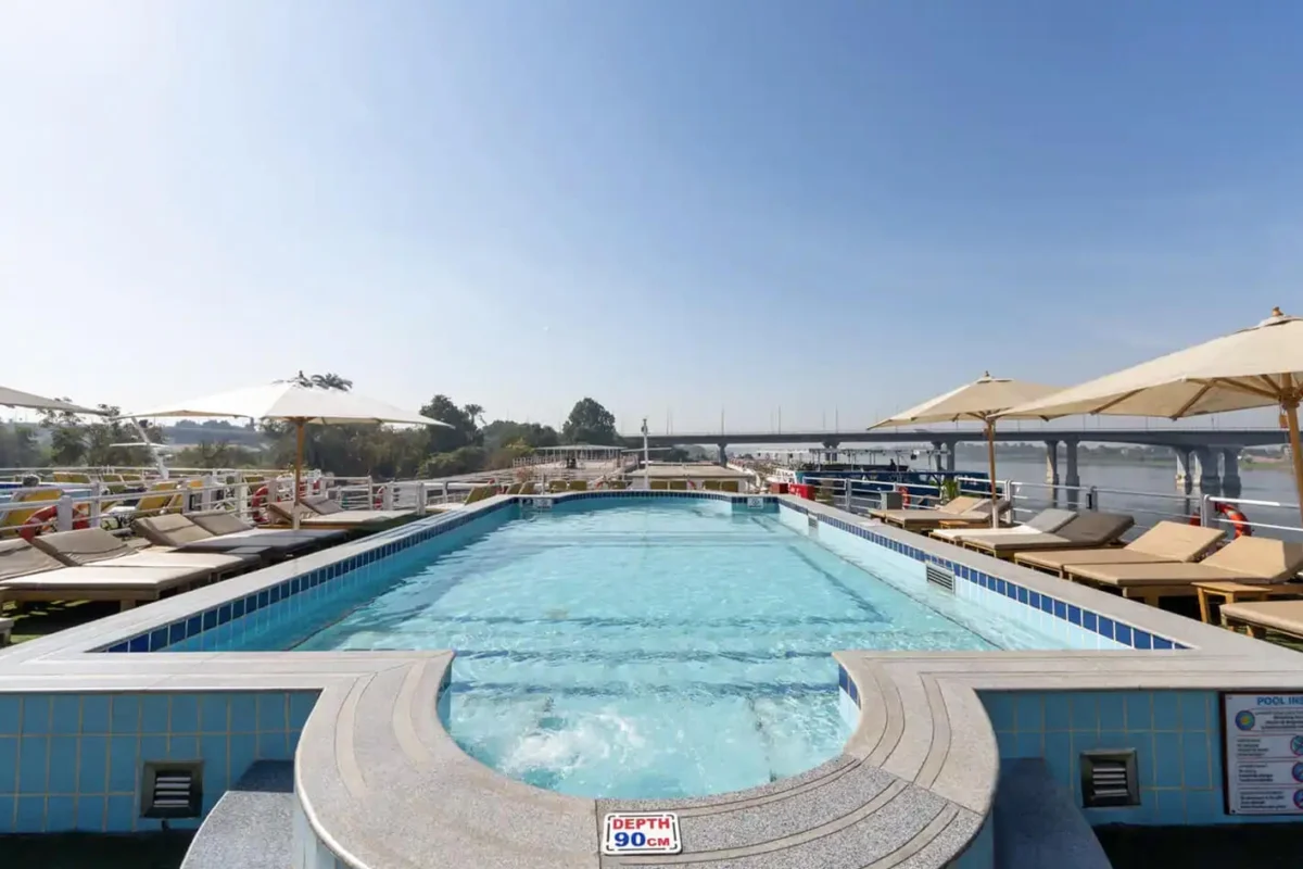 The swimming pool on the Magic I Nile cruise sun deck, loungers and parasols along the far side