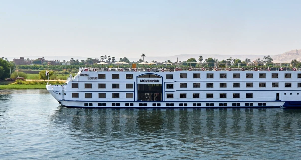 The Movenpick Royal Lotus Nile cruise ship under way on the Nile, seen broadside with its wake behind