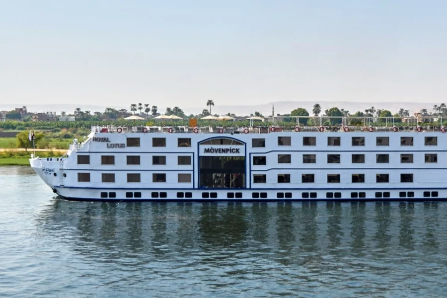 The Movenpick Royal Lotus Nile cruise ship under way on the Nile, seen broadside with its wake behind