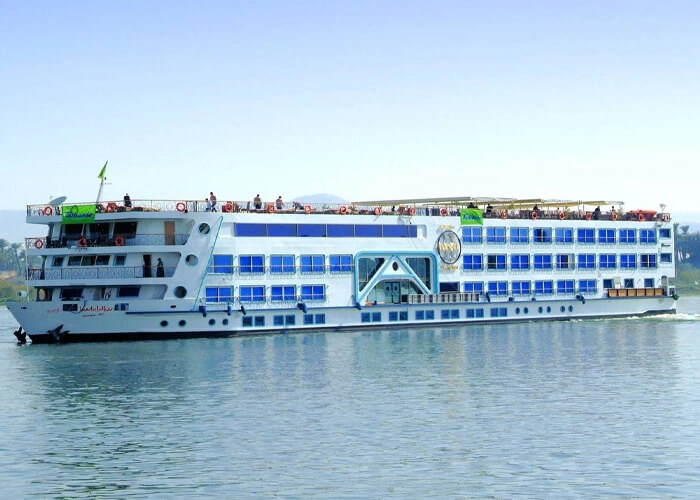 The Royal Esadora Nile cruise ship on the Nile, blue window bands running the length of its white hull