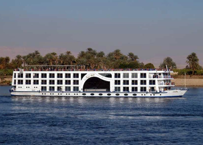 The Royal Princess Nile cruise ship on the Nile with the tall arched opening in its side, palms along the far bank