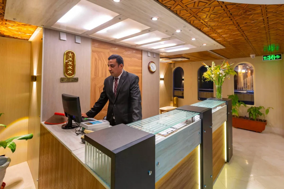 A member of staff at the reception desk of the Solaris I Nile cruise, a decorated ceiling above