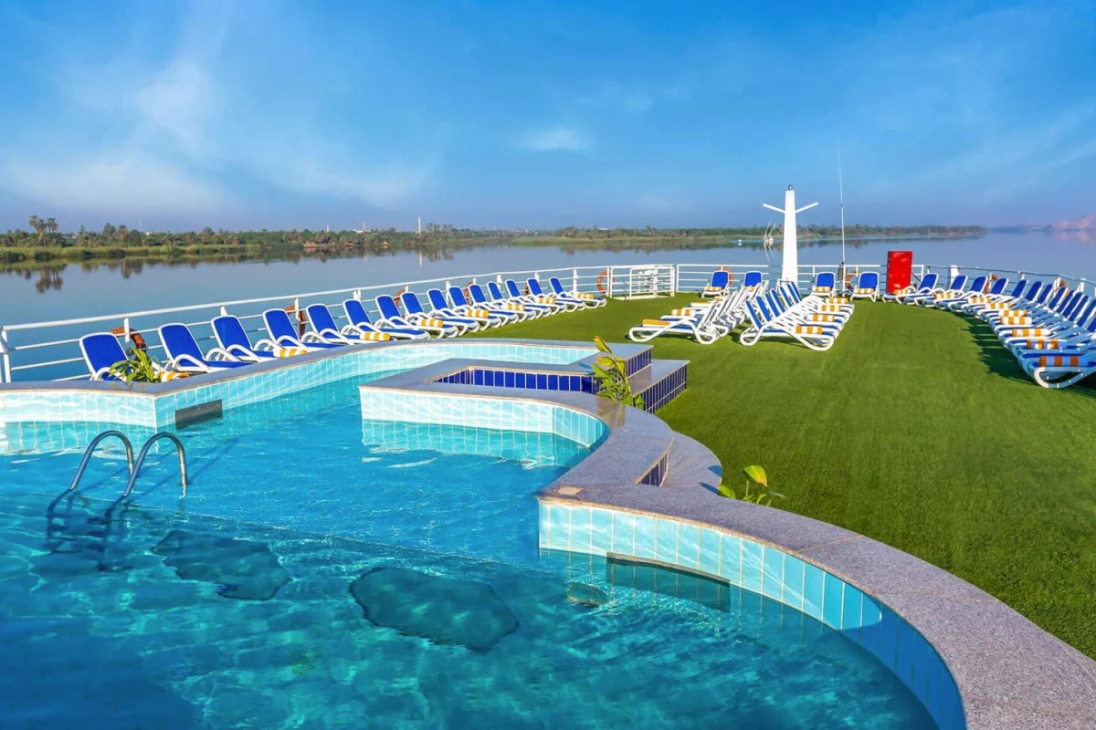 The swimming pool on the Solaris I Nile cruise sun deck, blue loungers set out on green matting around it