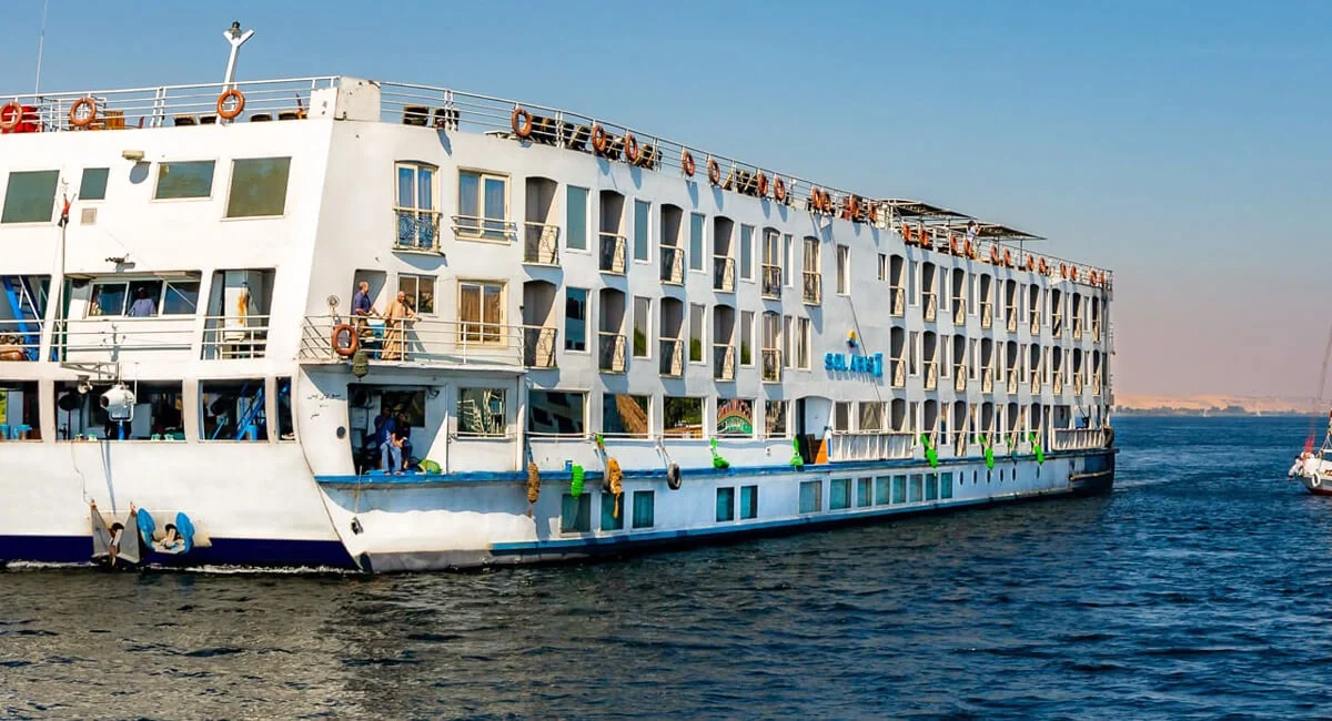 The Solaris II Nile cruise ship broadside on the Nile, a felucca passing on the open water
