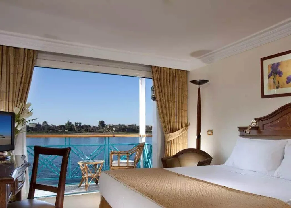 A cabin on the Sonesta Moon Goddess Nile cruise, the bed beside an open balcony door looking onto the river