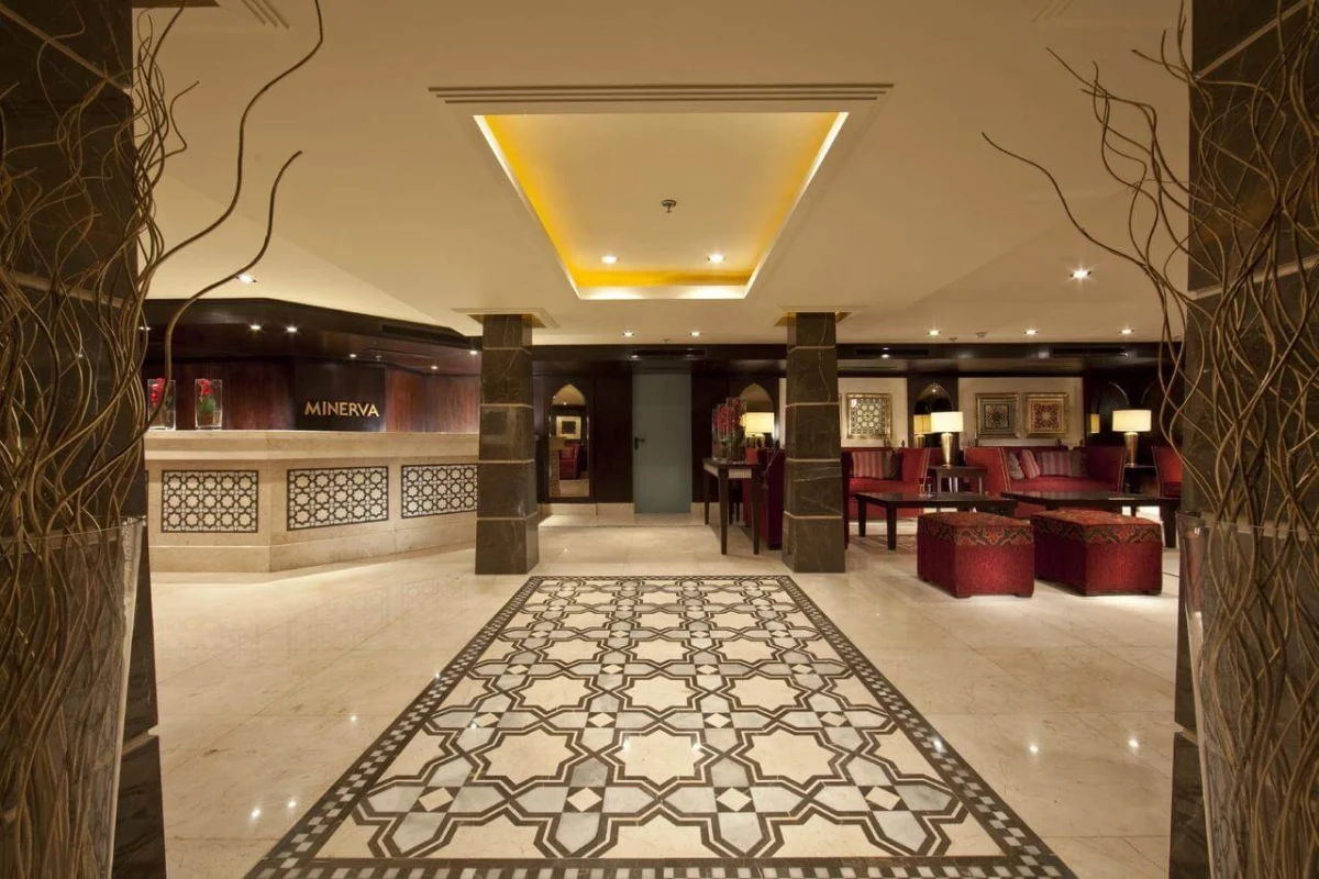 The lobby of the Steigenberger Minerva Nile cruise, a patterned stone floor between marble columns with red seating beyond