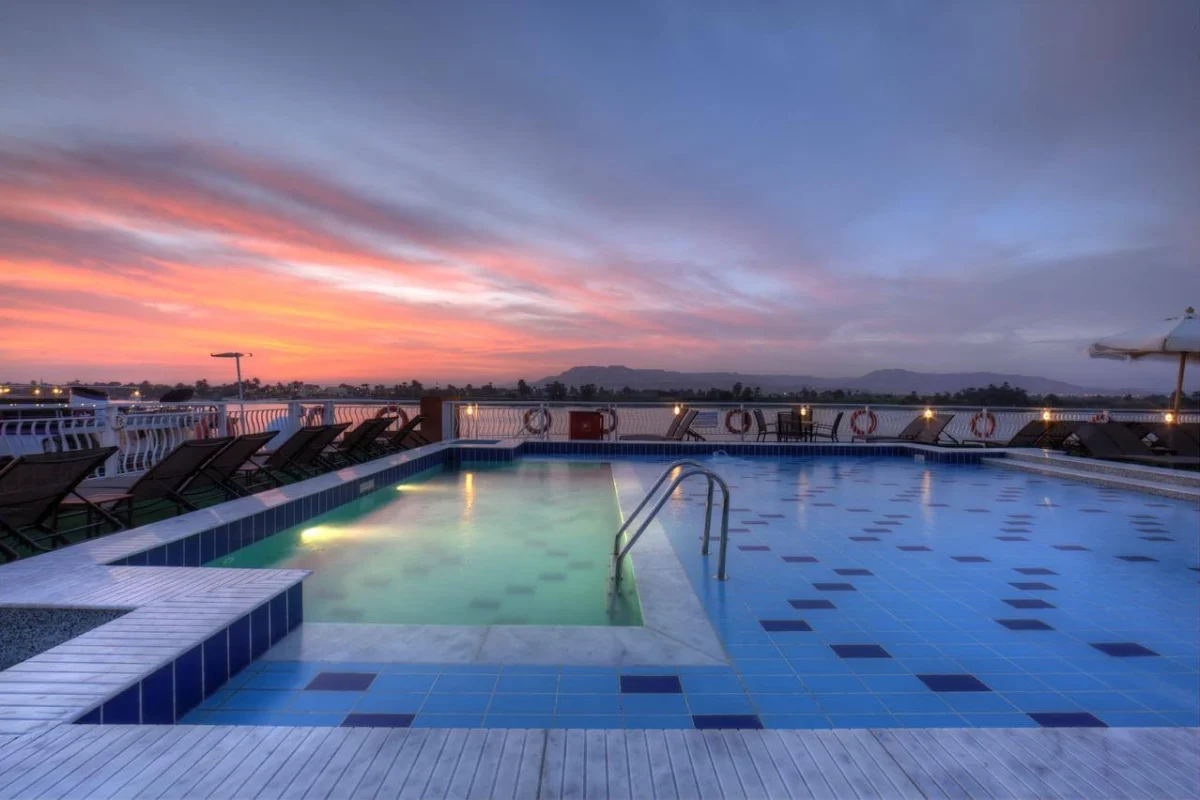 Der Swimmingpool auf dem Sonnendeck der Nilkreuzfahrt Steigenberger Minerva unter rosafarbenem Abendhimmel