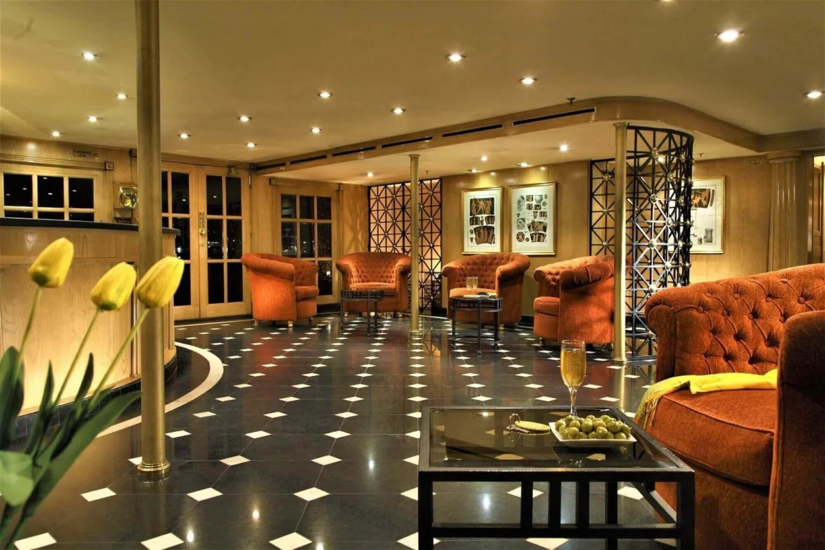 The lounge on the Steigenberger Regency Nile cruise, orange armchairs on a chequered floor with tulips on the near table