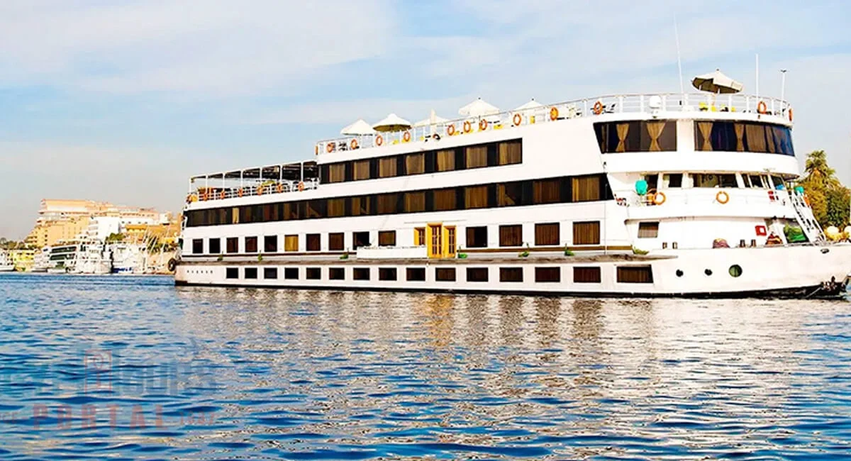 The Steigenberger Regency Nile cruise ship broadside on the Nile, palms and a riverside town behind