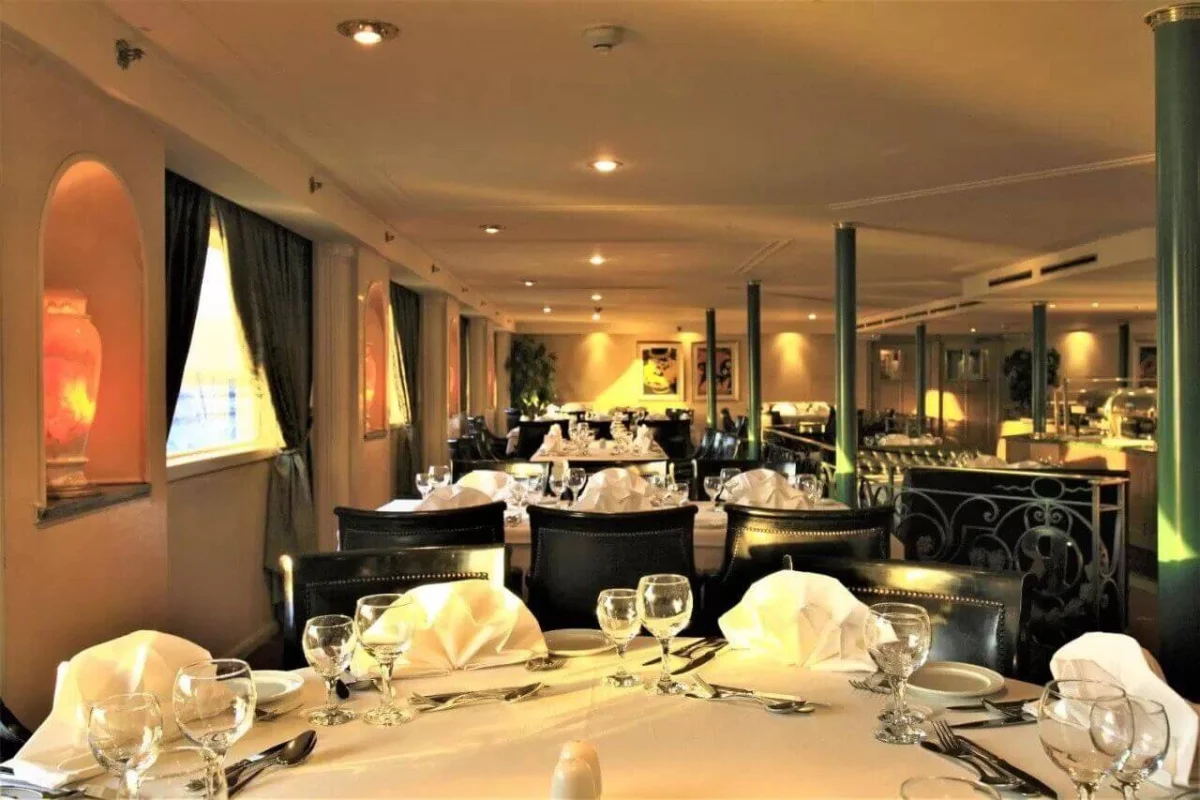 Tables laid with white linen and glassware in the Steigenberger Royale Nile cruise restaurant