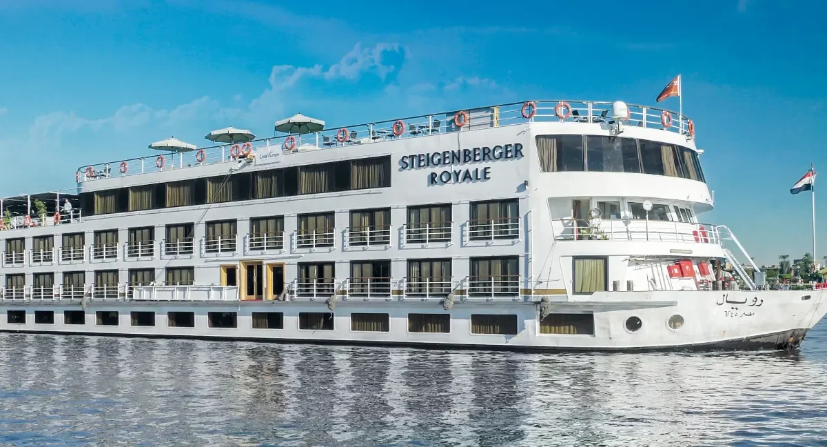 The Steigenberger Royale Nile cruise ship under way on the Nile, a riverside town low on the far bank