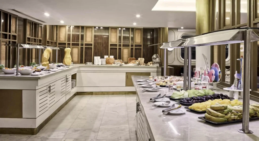 The buffet counter on the Tulip Nile cruise laid with fruit, salads and breads under warm downlights